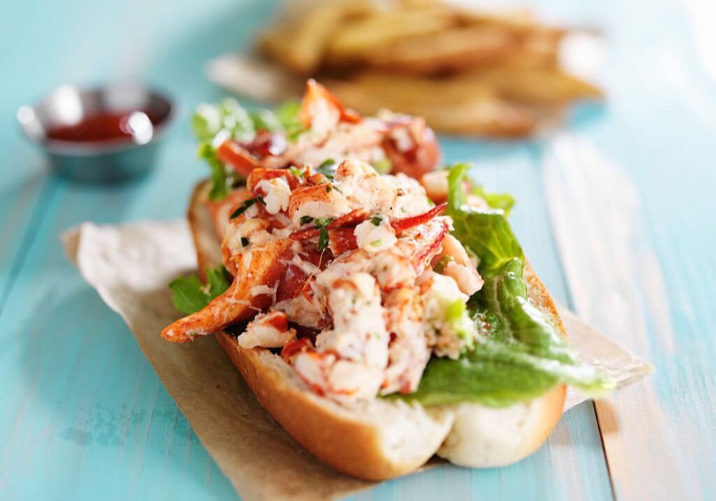 lobster roll on colorful retro painted wooden planks shot close up